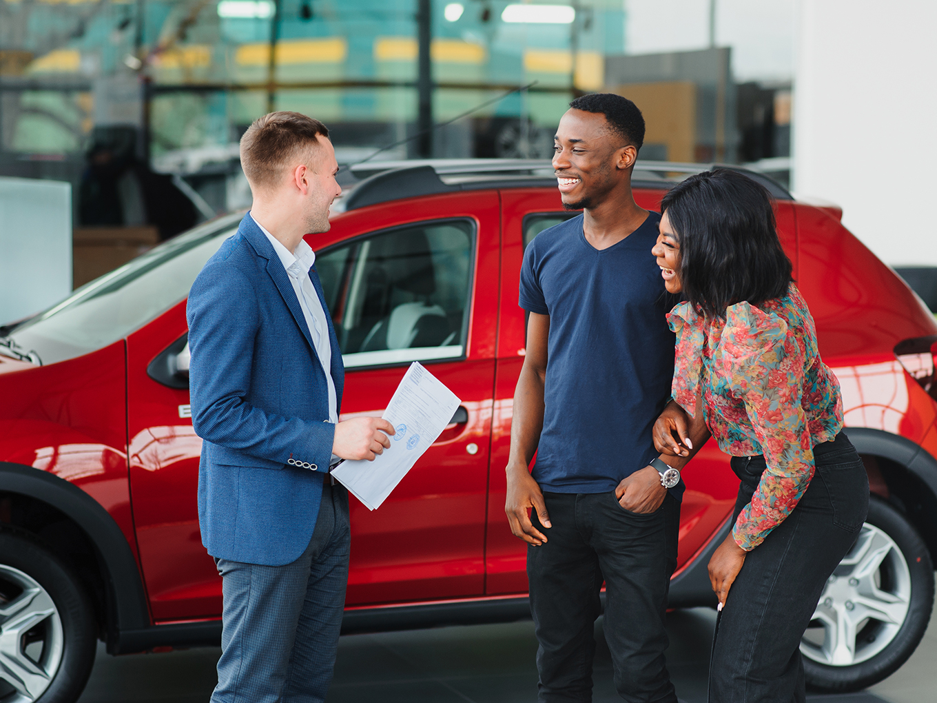 Smiling Couple Being Shown Vehicle by Car Salesman Smiling Couple Being Shown Vehicle by Car Salesman